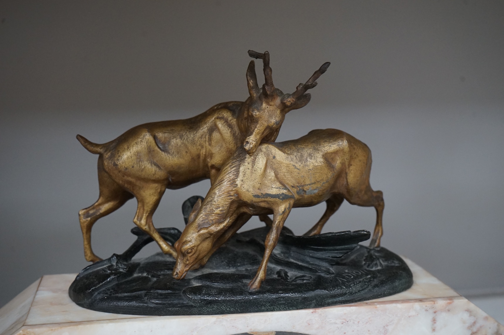 An Art Deco marble clock garniture and a French clock surmounted with two deer, with key, 44cm wide